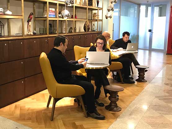 Business professionals working and networking at Servcorp Louis Vuitton Orjin Building’s modern hot desk..