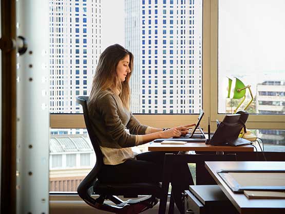 Professional working in a Servcorp dedicated office with a city view—flexible workspace with premium amenities and support.