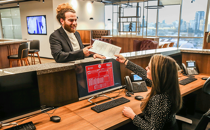 Coworking Space at Qubic Square with receptionist handling calls, mail, and clients working at hot desks.