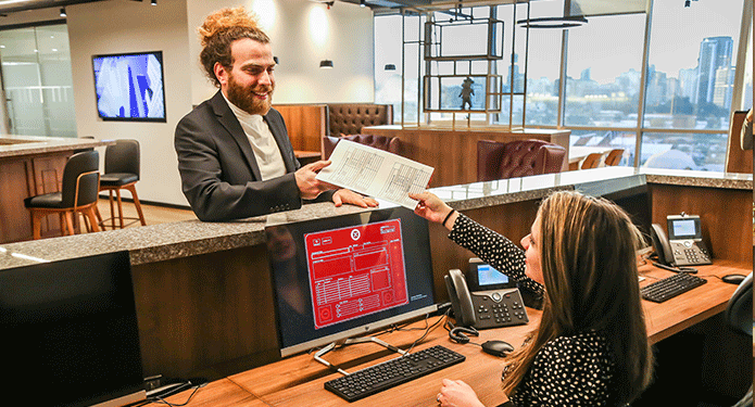 Coworking Space at Qubic Square with receptionist handling calls, mail, and clients working at hot desks.