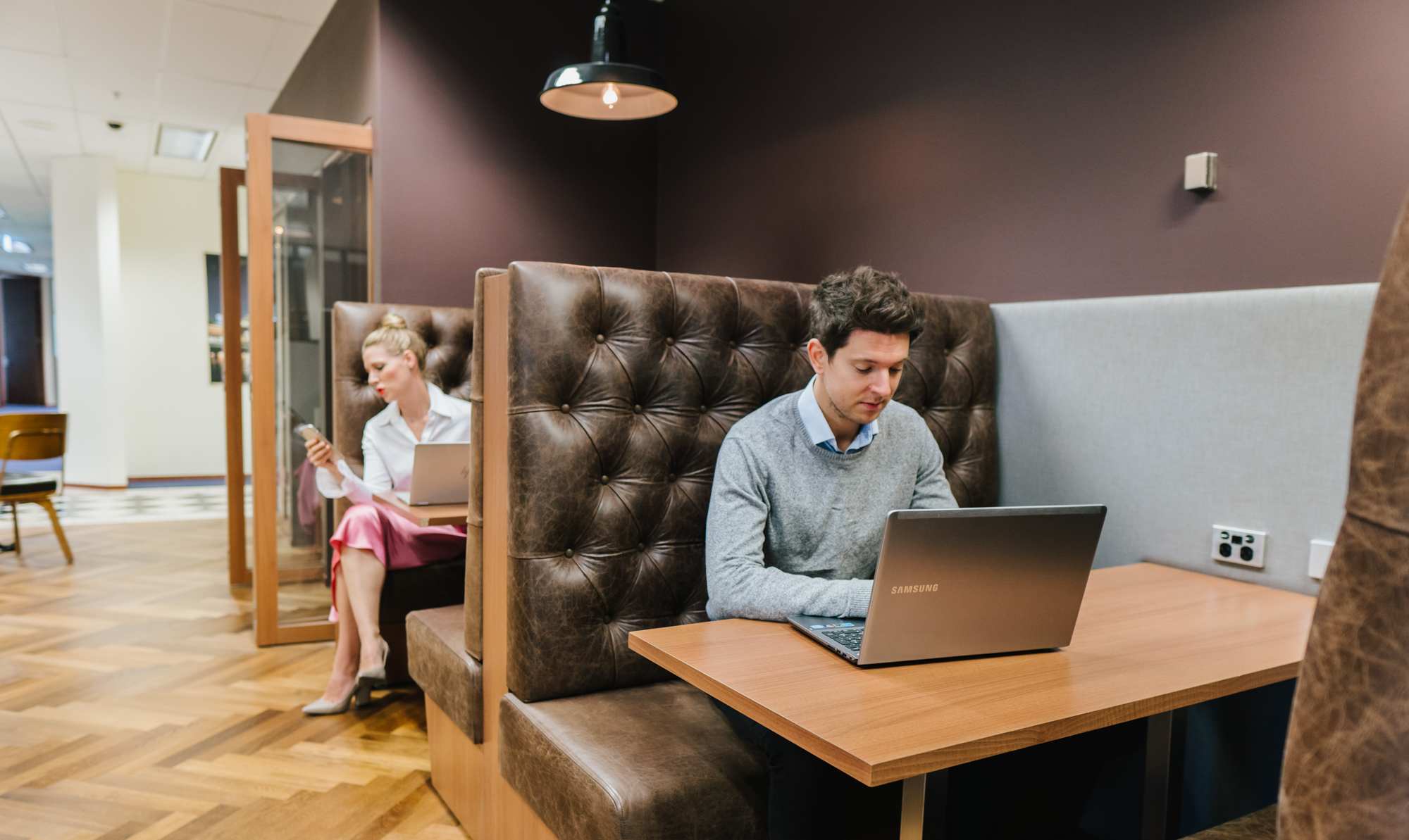 Clients making the most of Servcorp’s private booth seating—ideal for focused work in a coworking space.