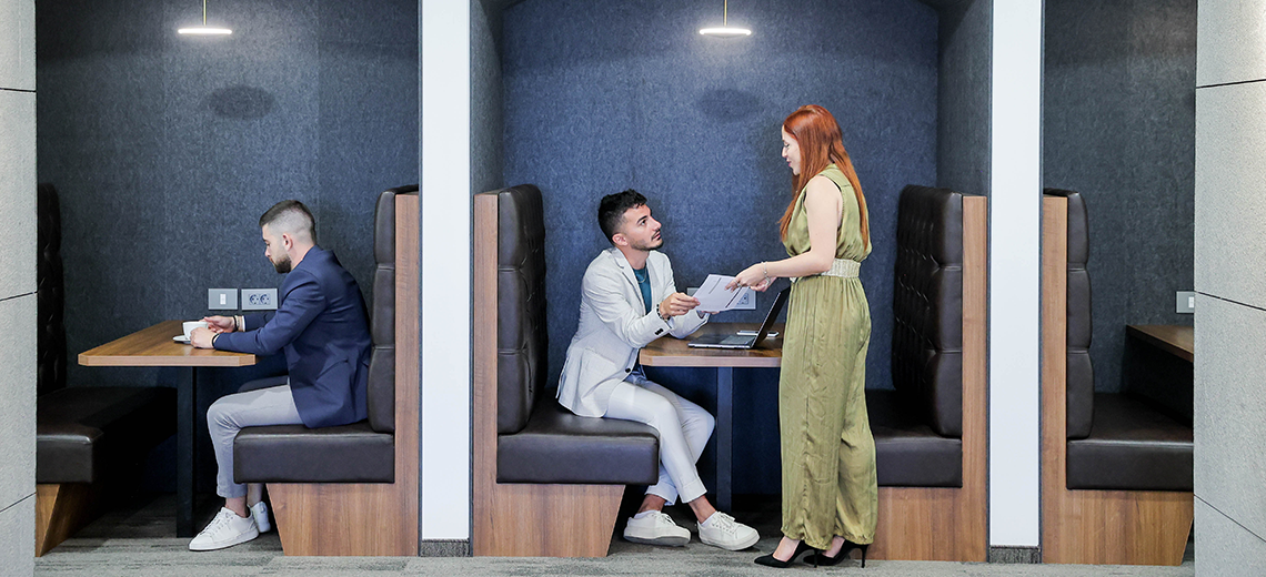 Coworking Space at Qubic Square with clients working and collaborating in an open hot desk area.