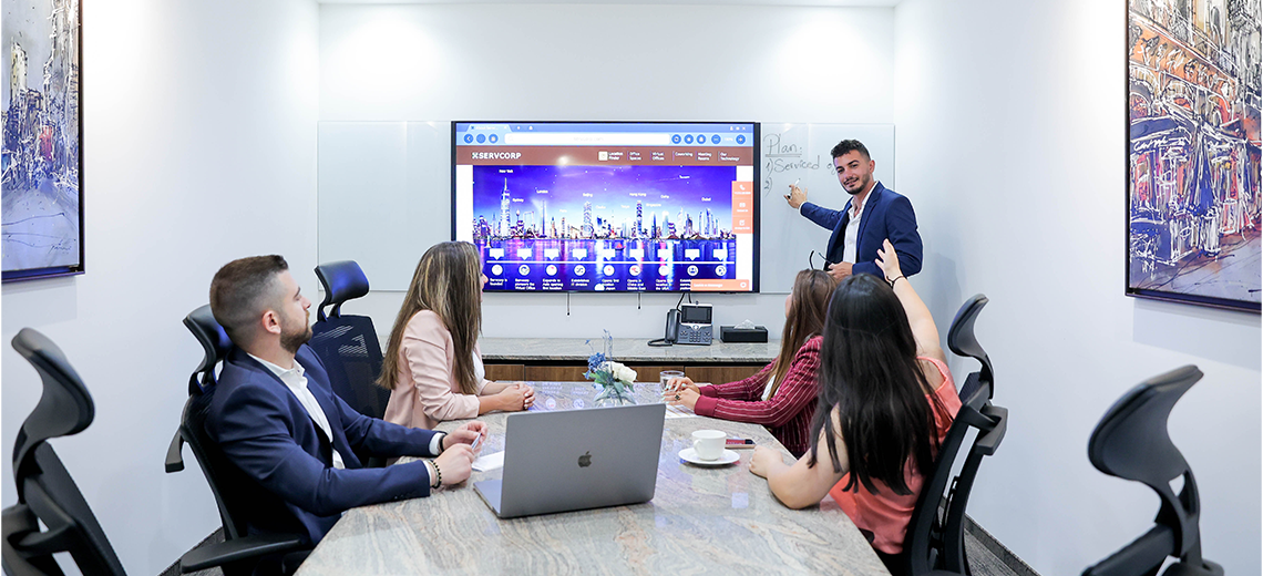Boardroom at Qubic Square with people meeting and presenting using high-tech, fully equipped facilities.