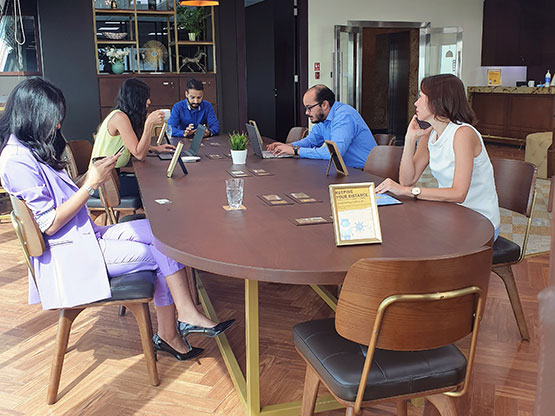  Servcorp coworking space, at Bahrain Financial Harbour, where professionals are working and interacting around a communal table in a stylish, well-lit environment