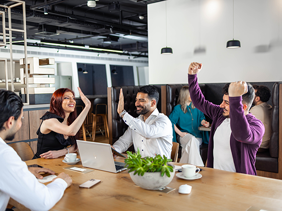 Clients celebrating their success in an open coworking space at Qubic Square.